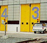 Yellow building with three doors and a truck parked in front