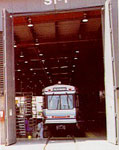 A train parked inside a garage, showcasing its sleek design and vibrant colors against the industrial backdrop