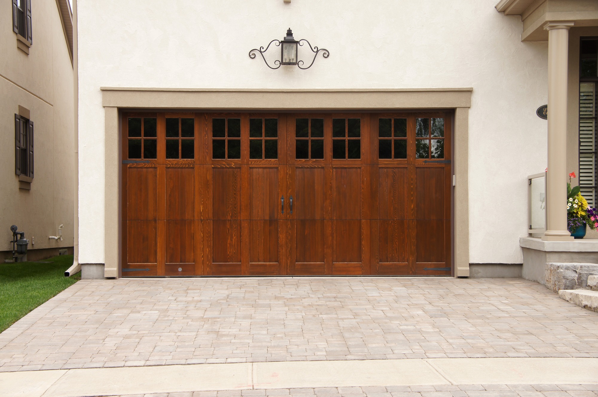 Wood double garage door and interlocking stone driveway